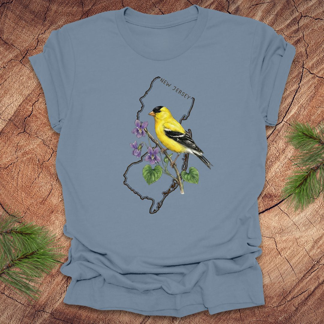 Steel blue t-shirt with a goldfinch and violets in a New Jersey state outline design on a wooden surface