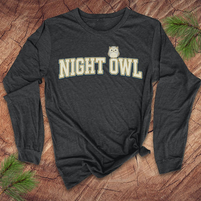 Dark gray long-sleeve shirt with 'NIGHT OWL' text and owl graphic on a wooden surface.