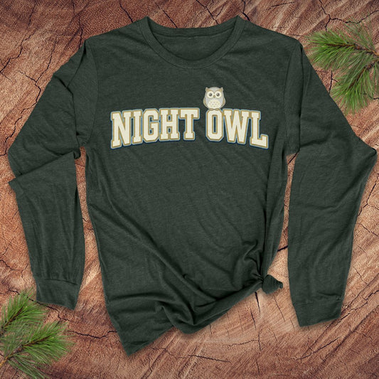 Green long-sleeve shirt with 'NIGHT OWL' text on a wooden surface