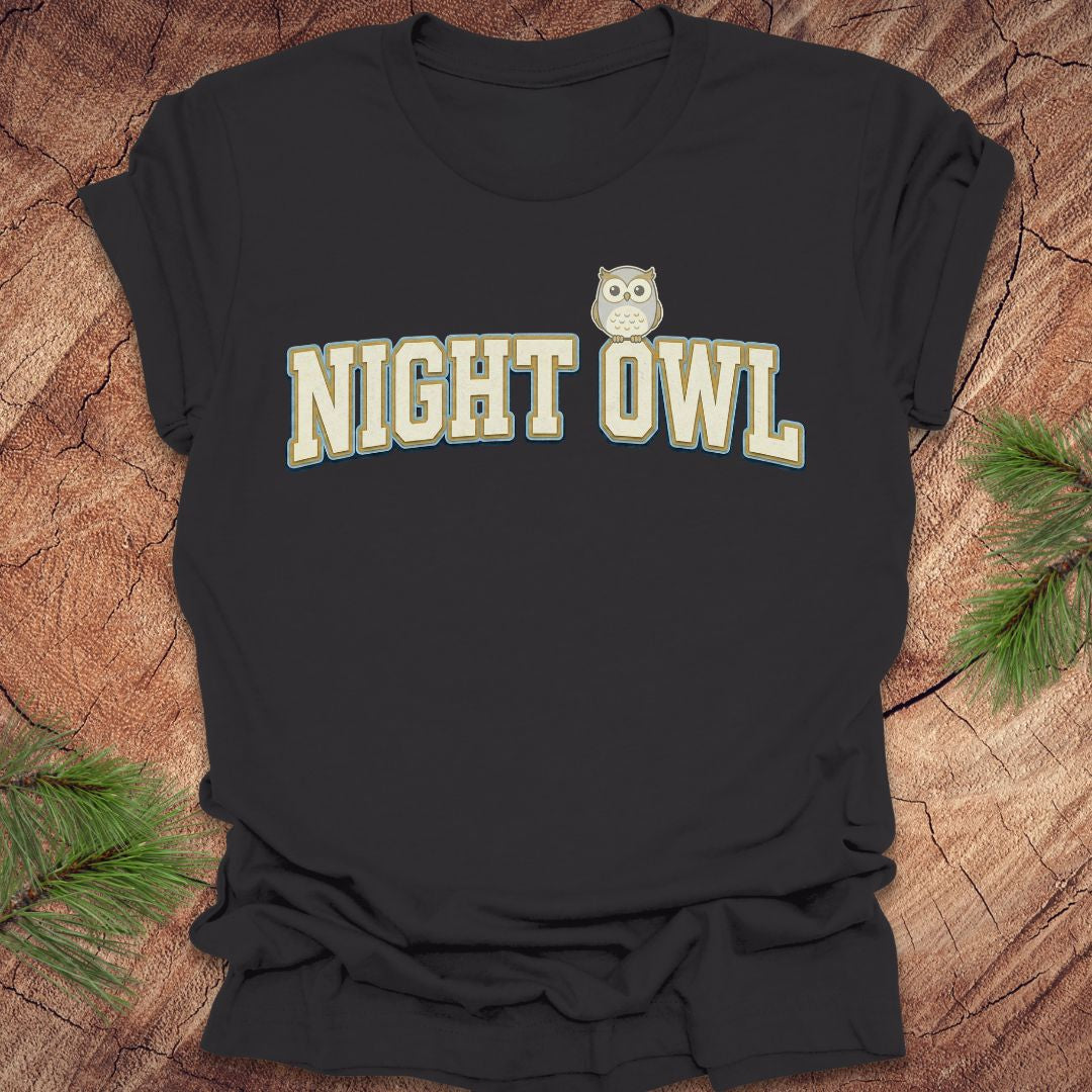 Dark gray t-shirt with 'NIGHT OWL' text and owl graphic on a wooden surface.