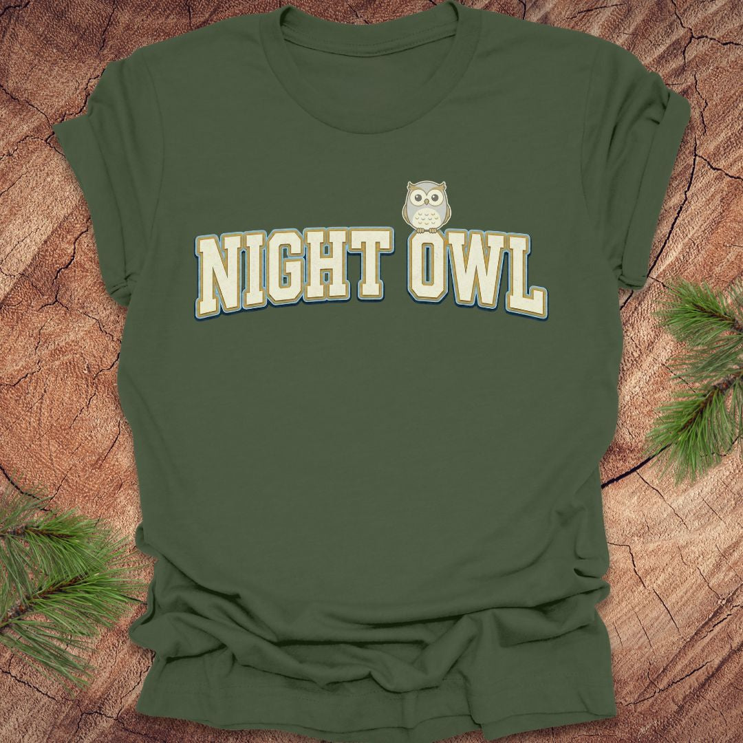 Green t-shirt with 'NIGHT OWL' text and owl graphic on a wooden surface.