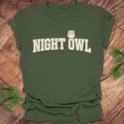 Green t-shirt with 'NIGHT OWL' text and owl graphic on a wooden surface.