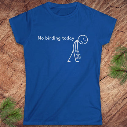 A royal blue short-sleeve t-shirt with a white graphic print that reads 'No birding today' next to a simple stick figure carrying a birdhouse. The t-shirt is laid flat on a textured brown wood background with pine needles in the corners.