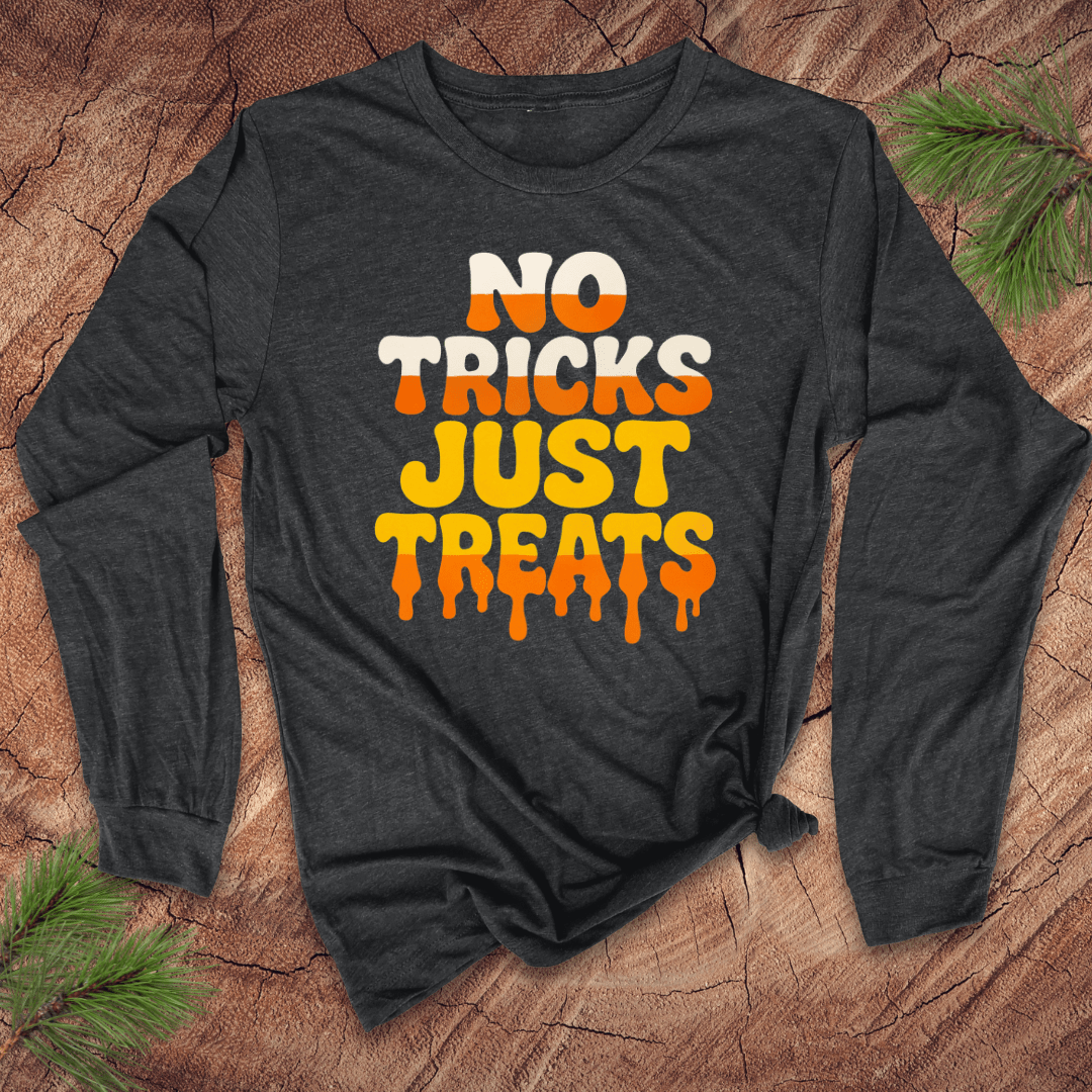 Dark gray long-sleeve shirt with 'No Tricks Just Treats' text on a wooden surface with pine branches.