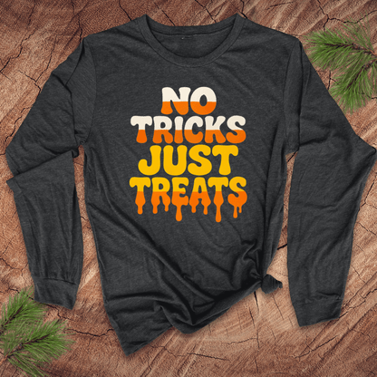 Dark gray long-sleeve shirt with 'No Tricks Just Treats' text on a wooden surface with pine branches.