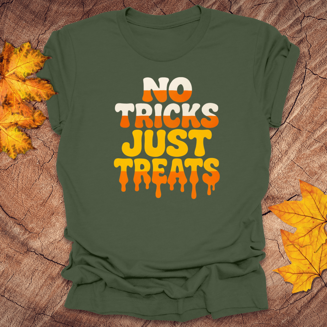 Green t-shirt with 'No Tricks Just Treats' text on a wooden surface with fall leaves.