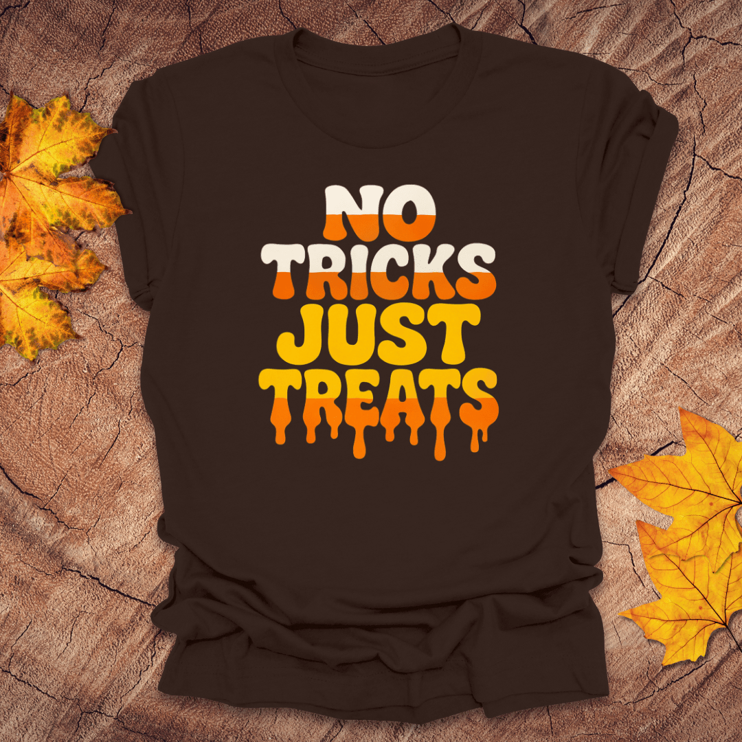 Brown t-shirt with 'No Tricks Just Treats' text on a textured surface with autumn leaves.