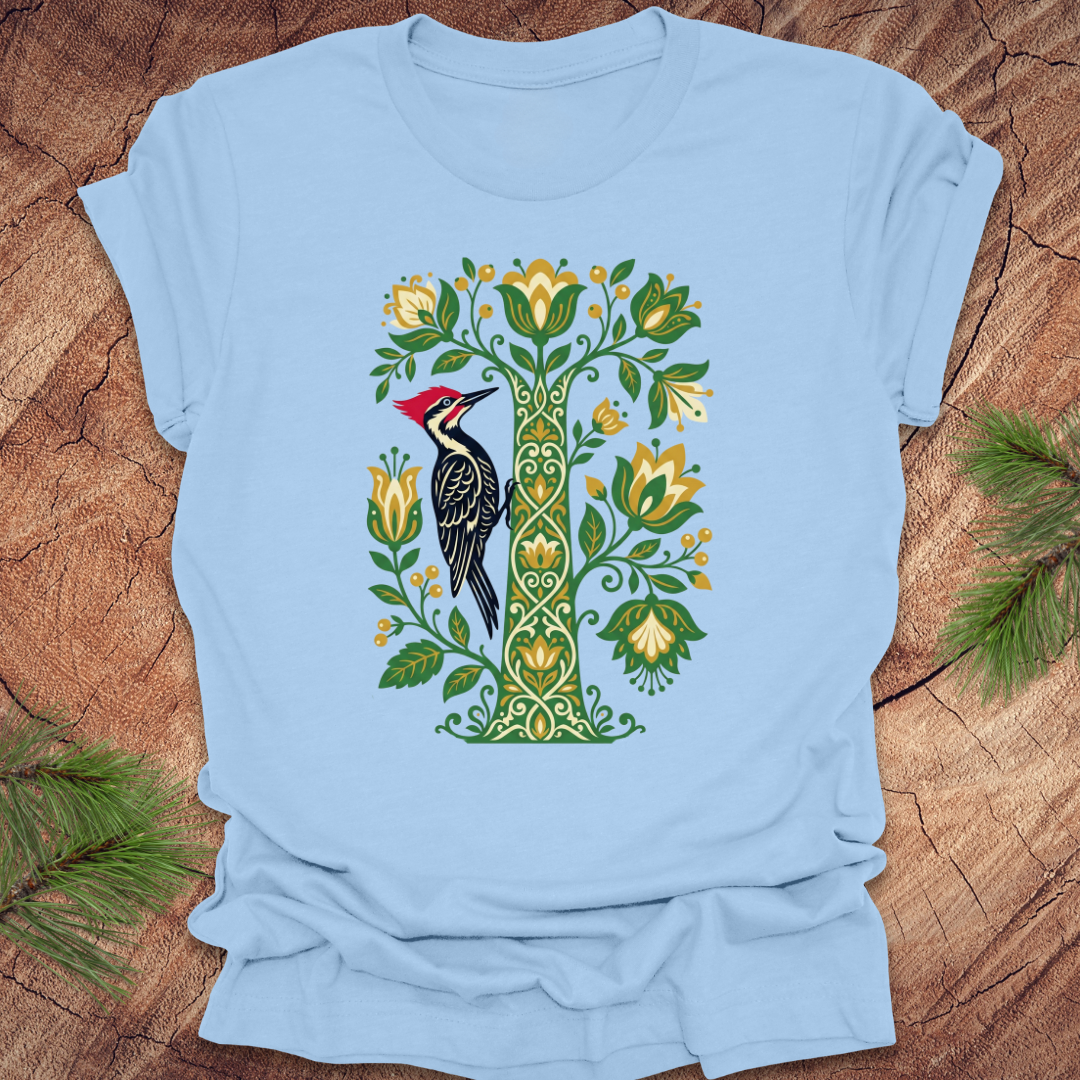 Light blue t-shirt with a woodpecker and floral design on a wooden surface