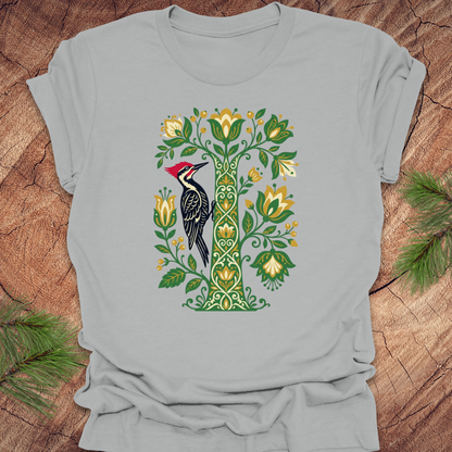 Gray t-shirt with a woodpecker and floral design on a wooden surface