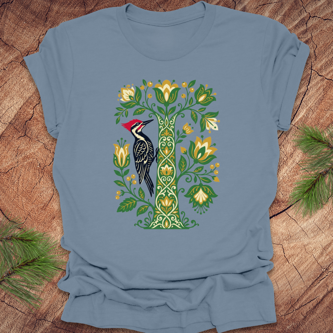 Blue t-shirt with a bird and floral design on a wooden surface