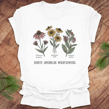 White t-shirt with North American wildflowers design on a wooden surface