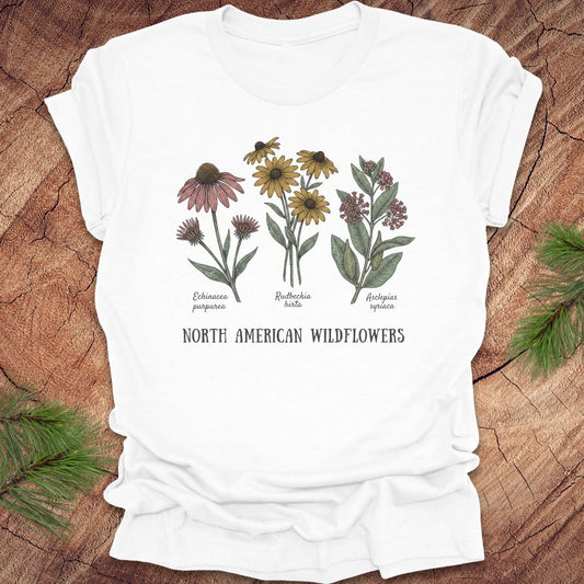 White t-shirt with North American wildflowers design on a wooden surface