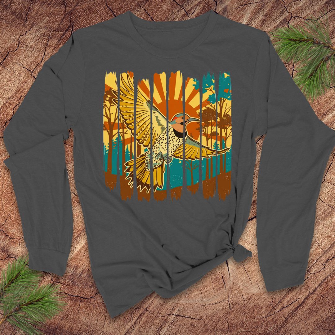 Gray long-sleeve shirt with a colorful northern flicker bird and sunrise design on a wooden surface