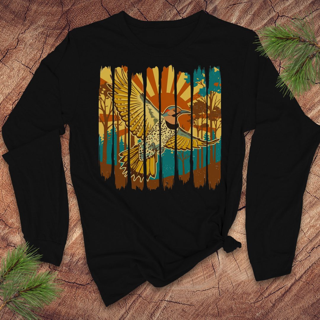 Black long-sleeve shirt with a colorful northern flicker bird and sunrise design on a wooden surface