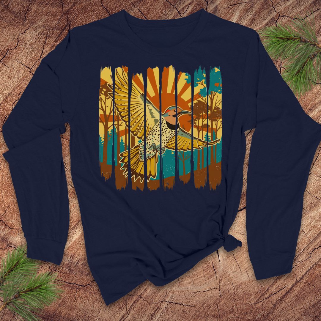 Navy blue long-sleeve shirt with a colorful northern flicker bird and sunrise design on a wooden surface