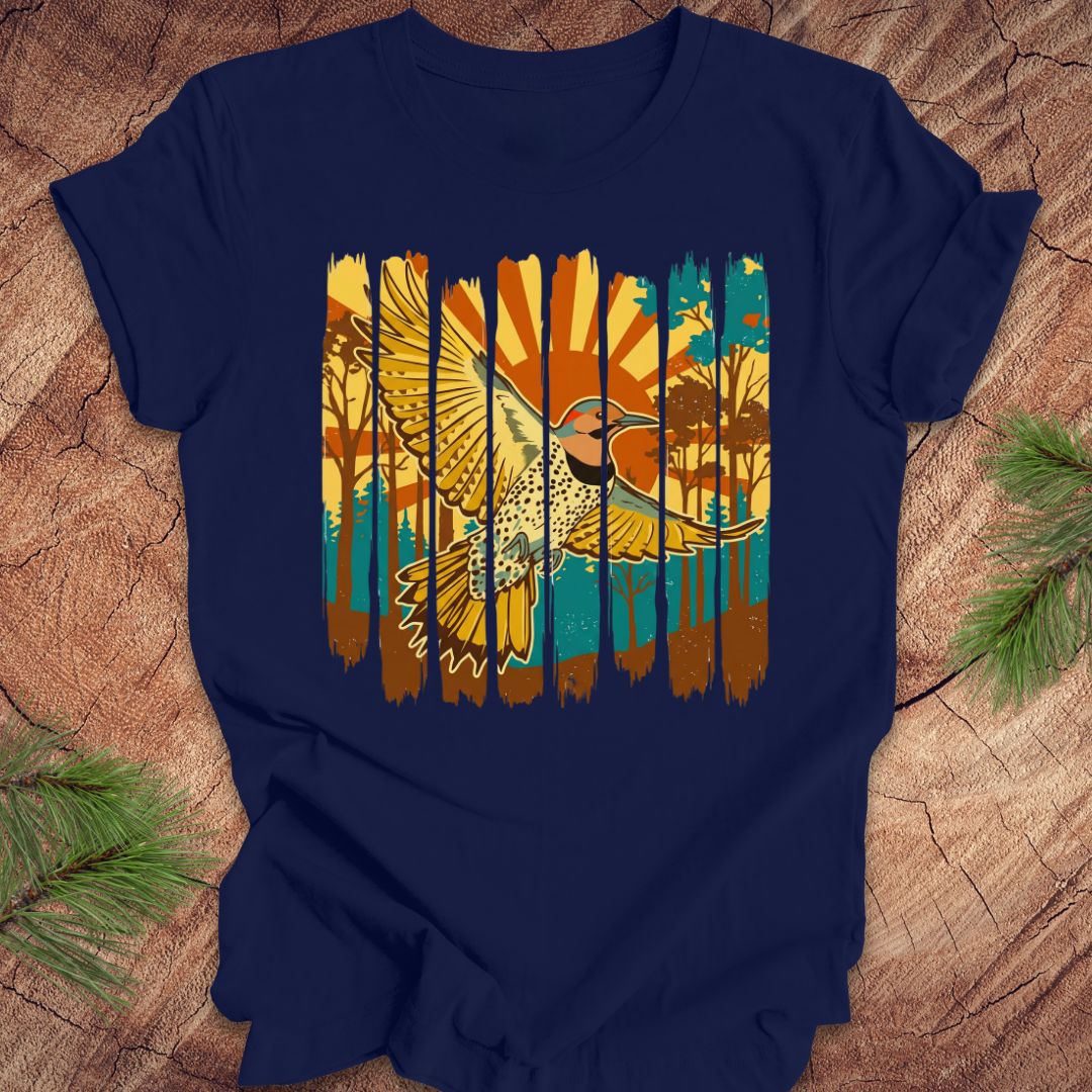 Navy blue t-shirt with a colorful graphic of a northern flicker and nature elements on a wooden surface.