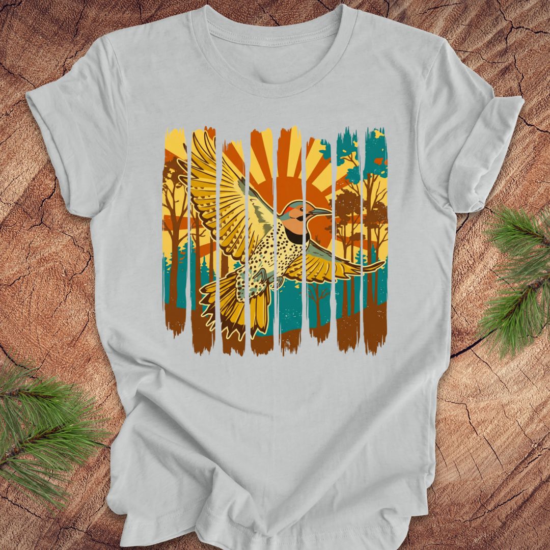 Gray t-shirt with a colorful graphic of a northern flicker and nature elements on a wooden surface.