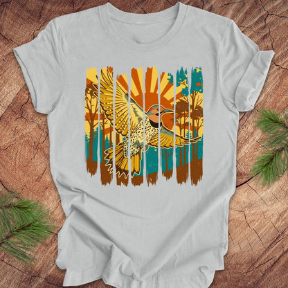 Gray t-shirt with a colorful graphic of a northern flicker and nature elements on a wooden surface.