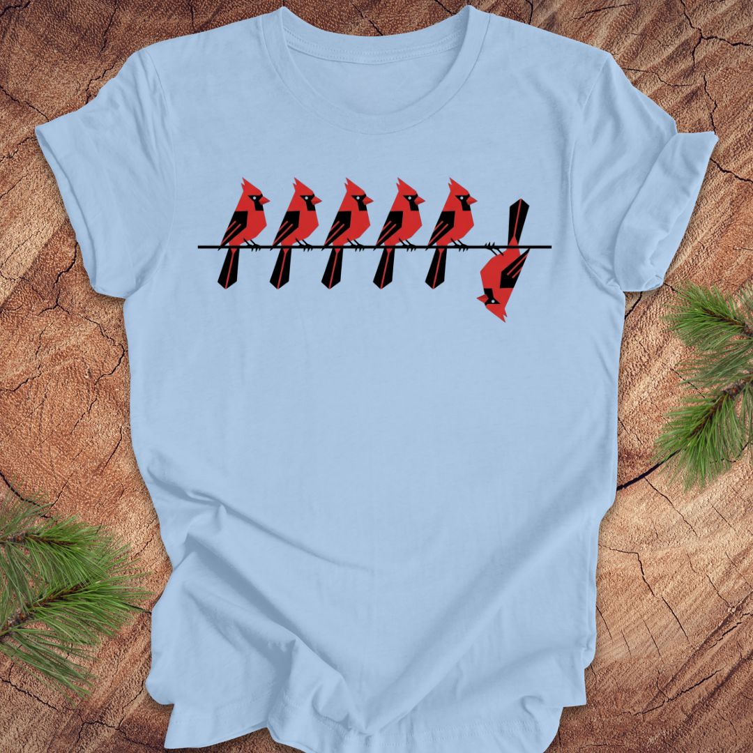 Light blue t-shirt with red cardinal design on a wooden surface