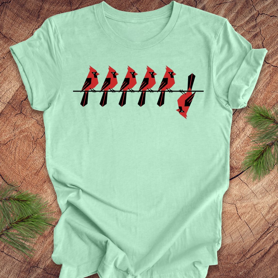 Light green t-shirt with red cardinal bird design on a wooden surface