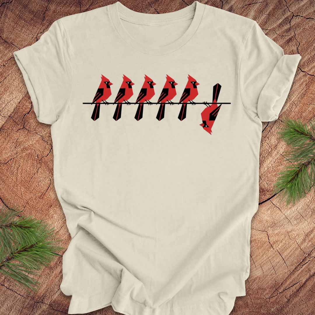 Beige t-shirt with red cardinal bird design on a wooden surface