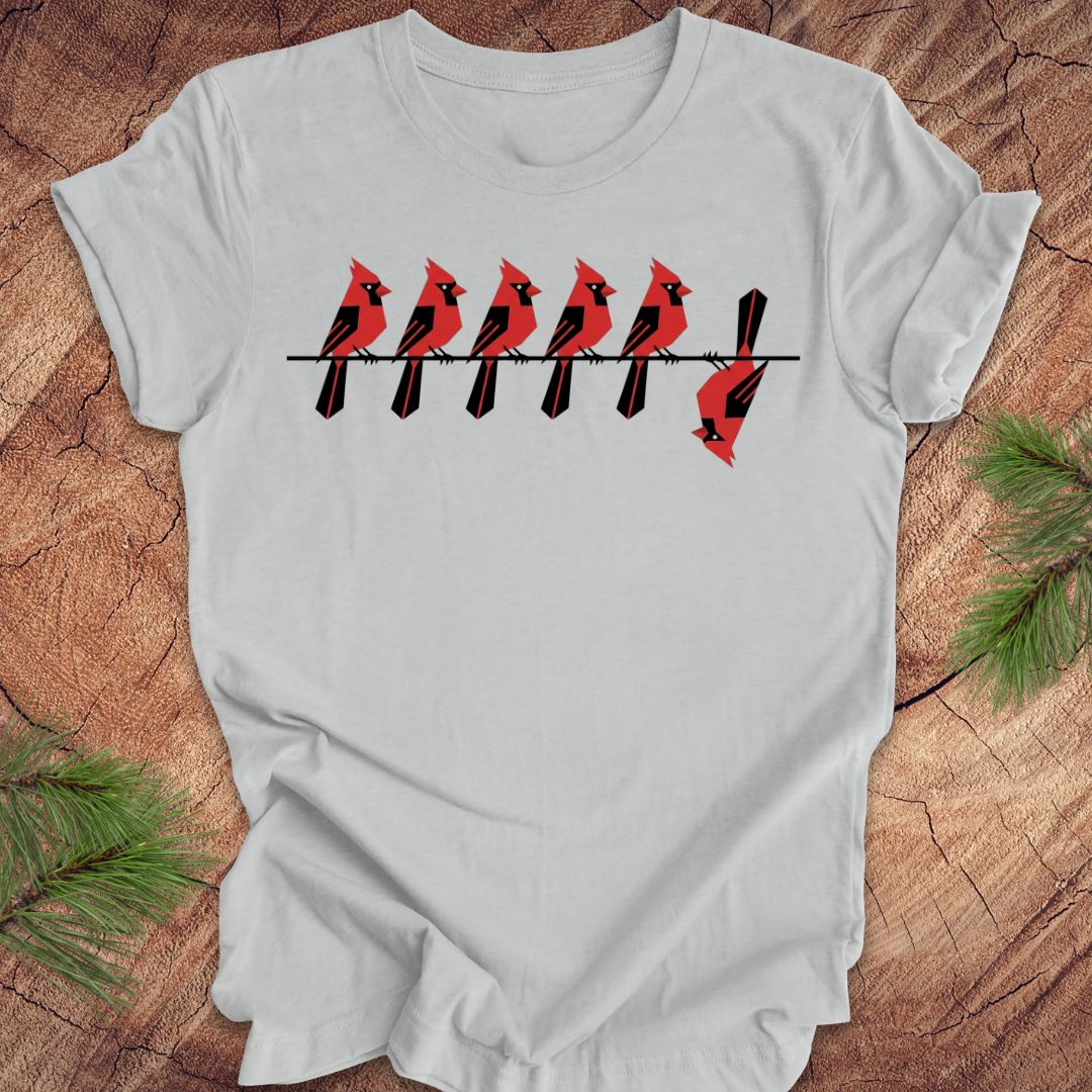 Gray t-shirt with red cardinal design on a wooden surface