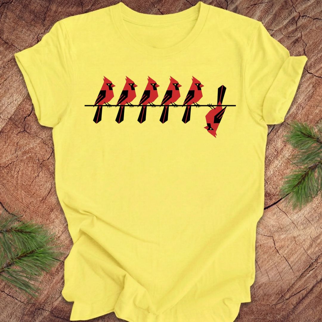 Yellow t-shirt with red cardinal bird design on a wooden surface