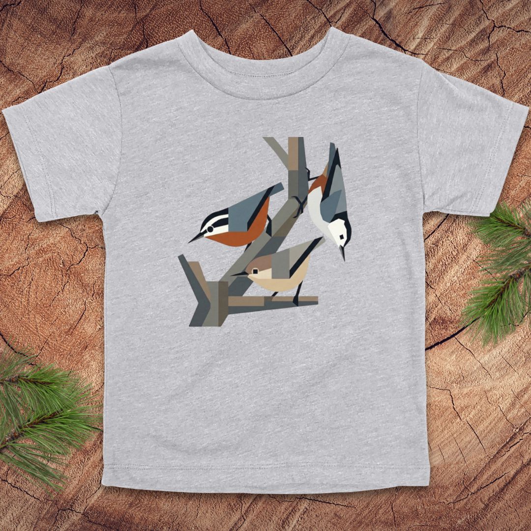 Gray toddler t-shirt with nuthatch bird design on a wooden surface