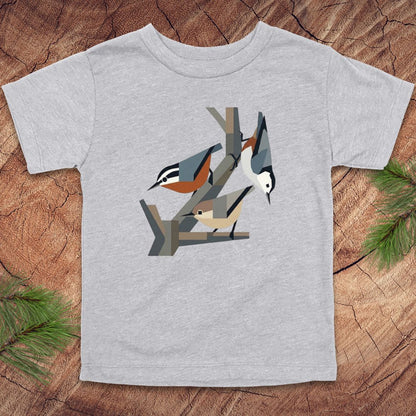 Gray toddler t-shirt with nuthatch bird design on a wooden surface