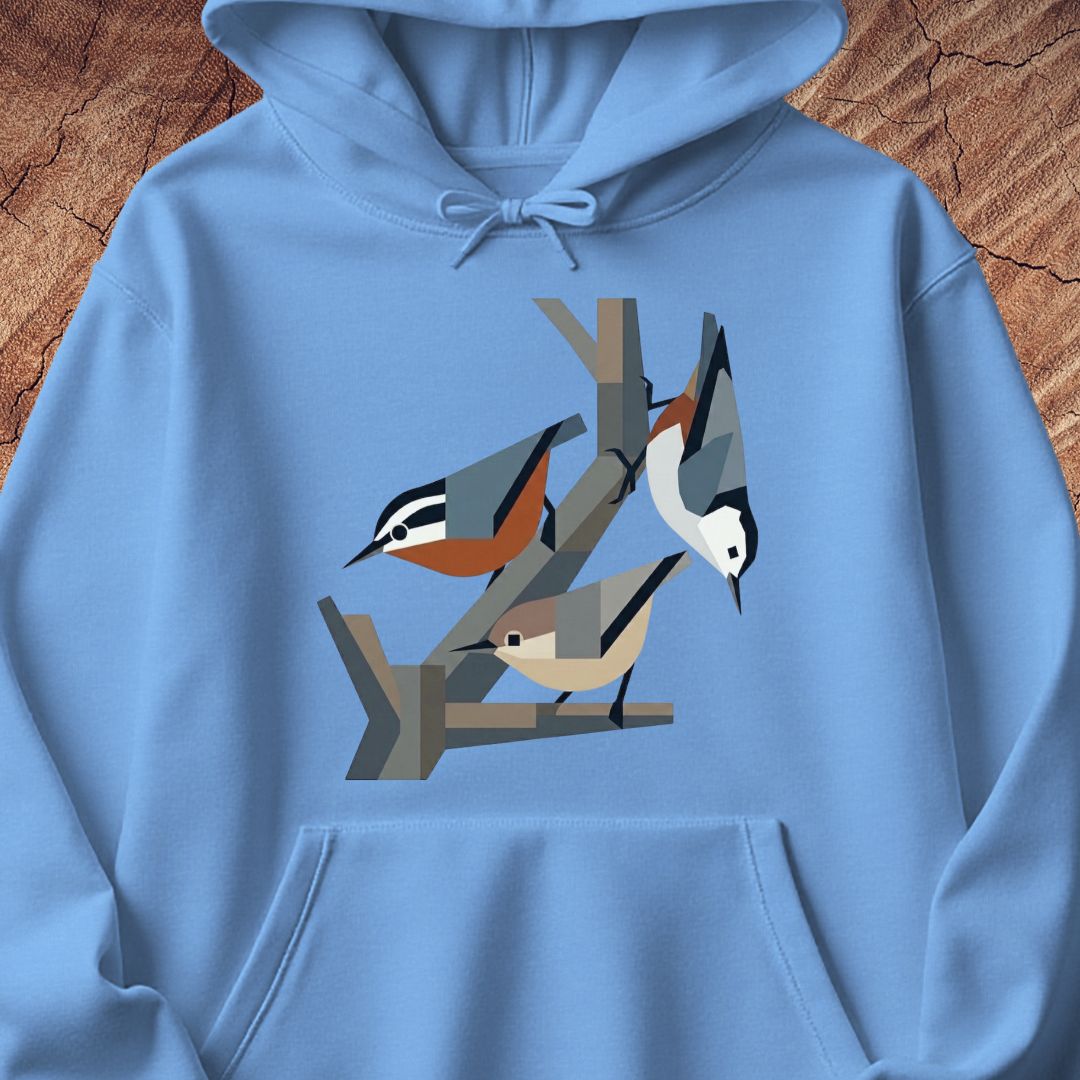 A light blue hoodie laid flat on a rustic wood background, featuring a stylized graphic of three birds perched on branches across the chest.
