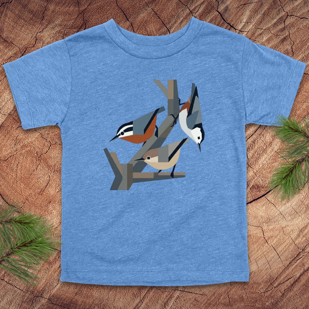 Blue toddler t-shirt with nuthatch bird design on a wooden surface