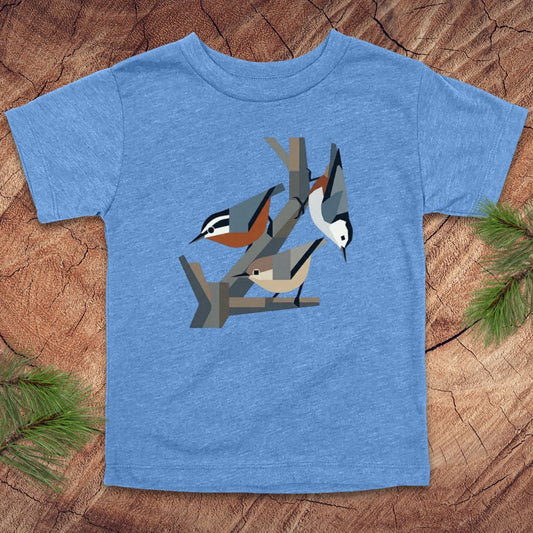 Blue toddler t-shirt with nuthatch bird design on a wooden surface