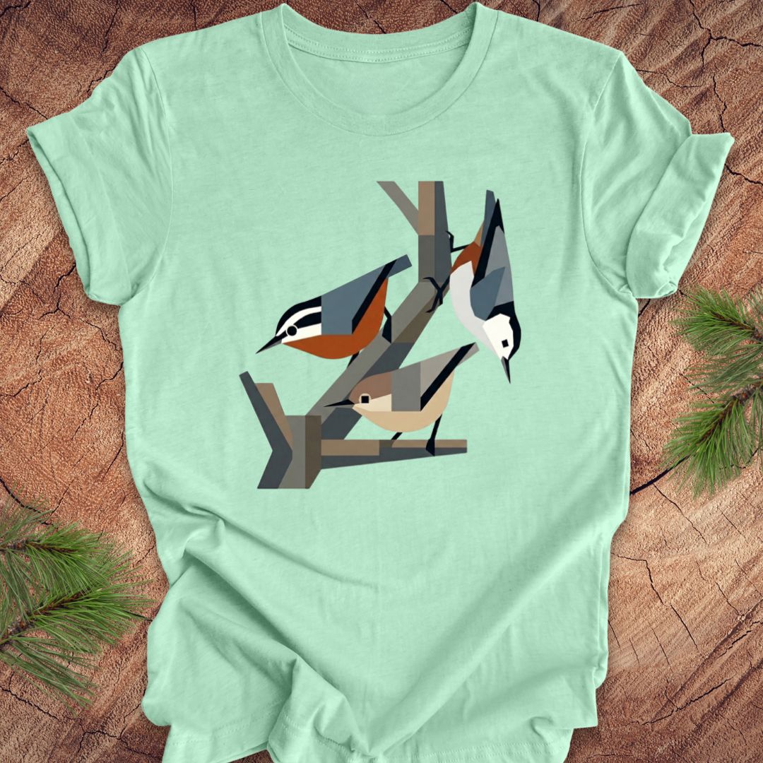 Mint green t-shirt with nuthatch design on a wooden surface
