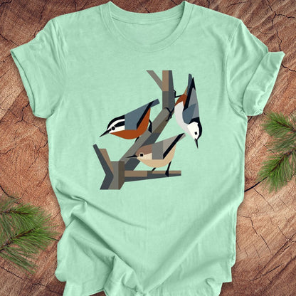 Mint green t-shirt with nuthatch design on a wooden surface