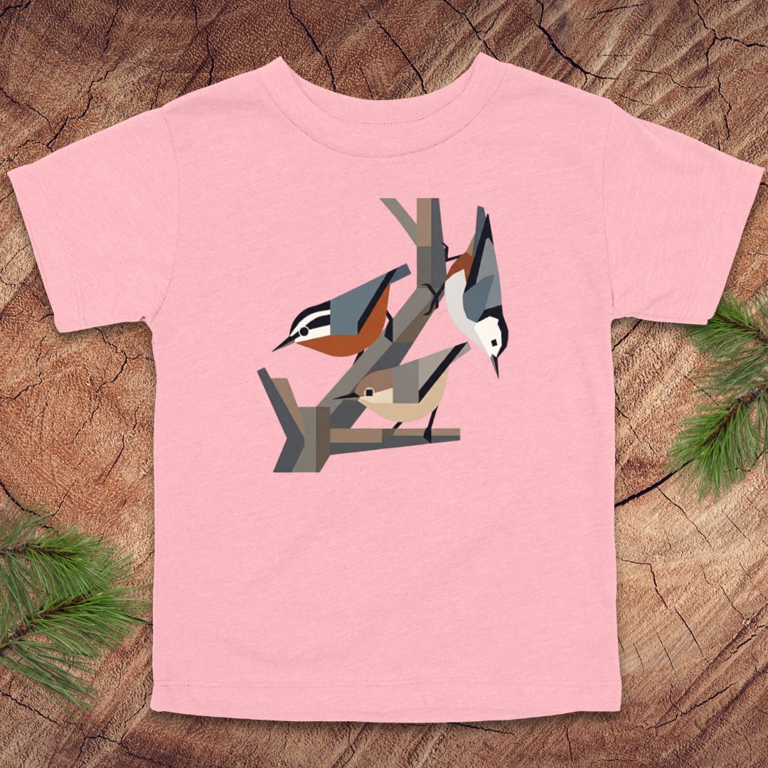 Pink toddler t-shirt with nuthatch bird design on a wooden surface
