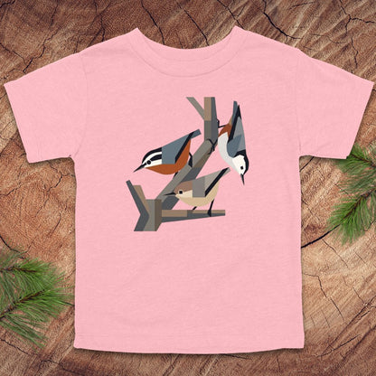 Pink toddler t-shirt with nuthatch bird design on a wooden surface
