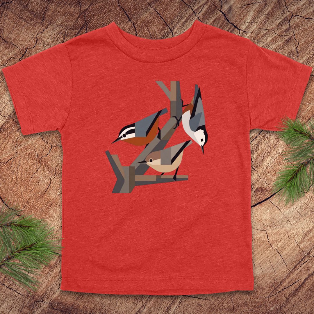 Red toddler t-shirt with nuthatch bird design on a wooden surface