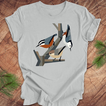 Gray t-shirt with nuthatch design on a wooden surface