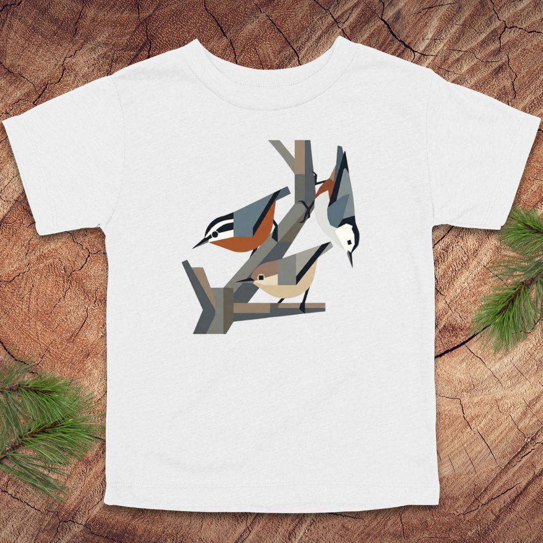 White toddler t-shirt with nuthatch bird design on a wooden surface