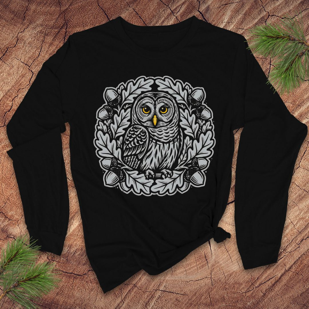 Black long sleeve tshirt with an oak tree and owl design on a wooden surface