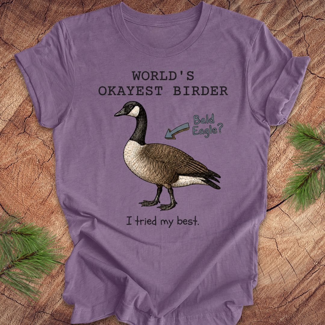 Purple t-shirt with a goose graphic and text on a wooden surface