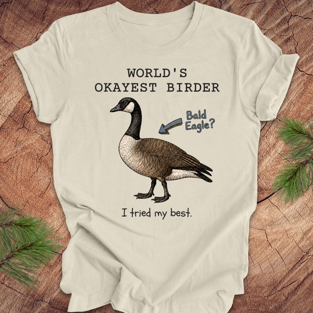 Beige t-shirt with a goose illustration and text on a wooden surface
