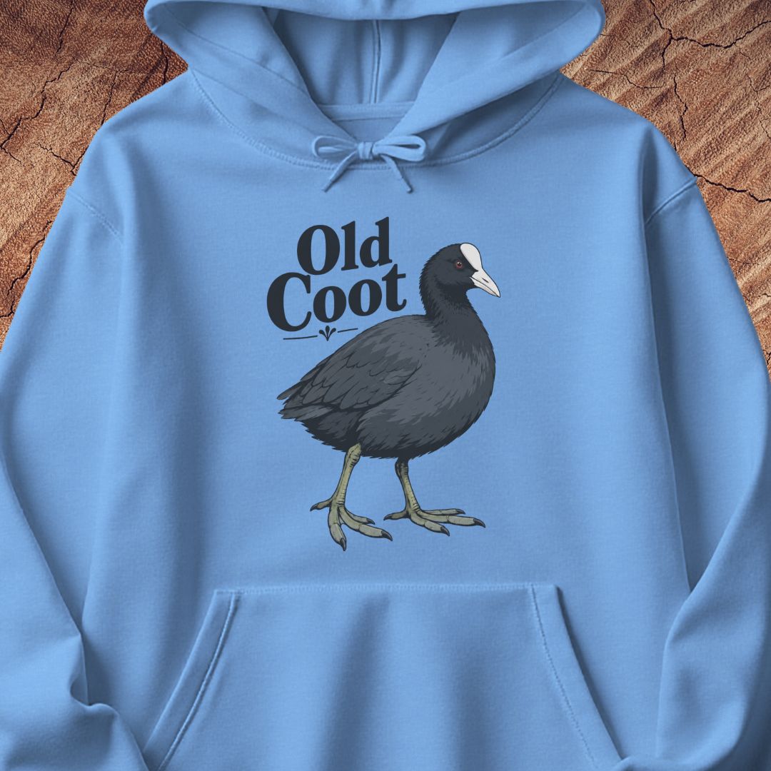 A light blue hoodie laid flat on a rustic wood background, featuring a printed graphic of a dark coot bird and the words 'Old Coot' in black lettering.