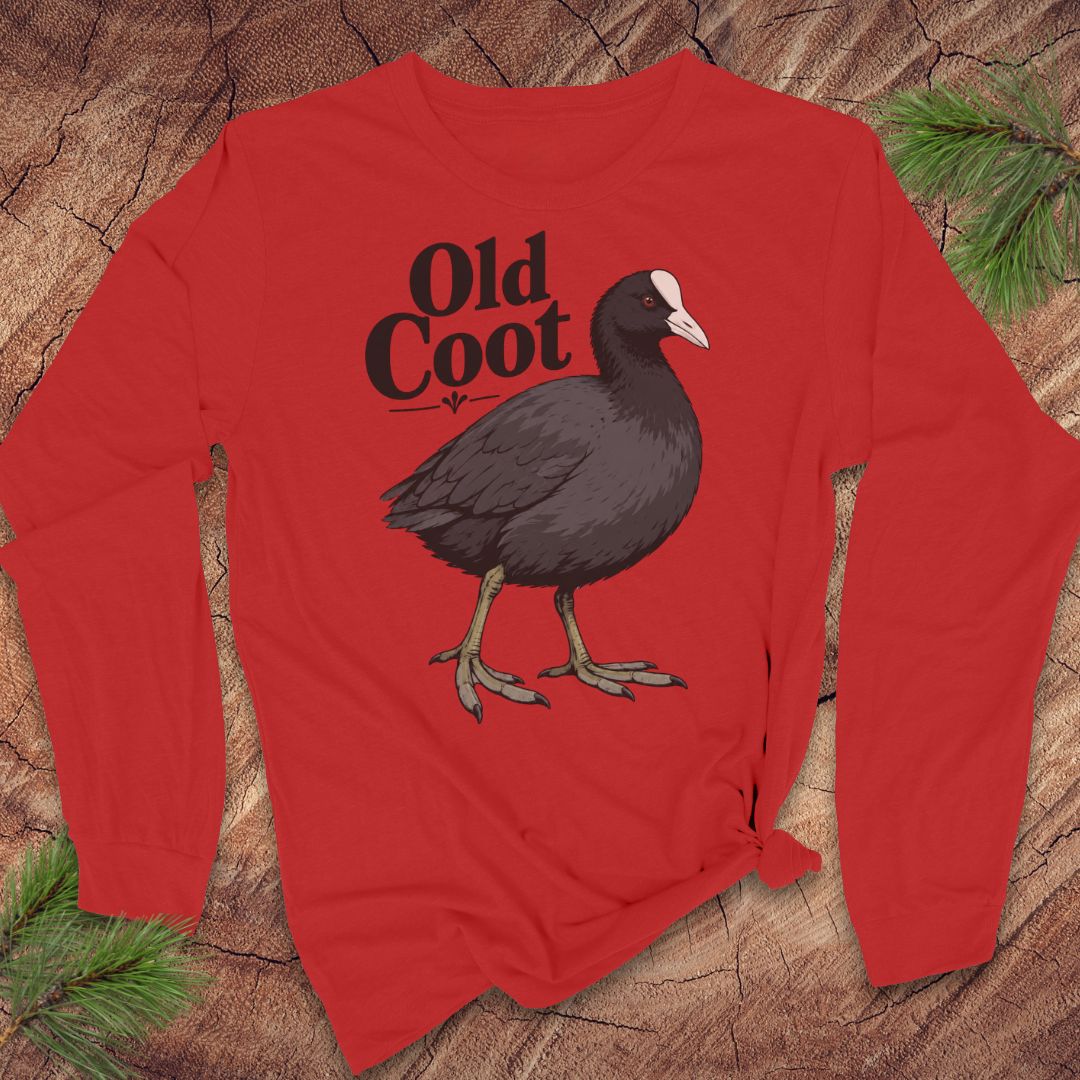 A red long-sleeve t-shirt with a graphic of a dark coot bird and the text 'Old Coot' printed on the chest, displayed flat on a rustic wood background with pine needles.