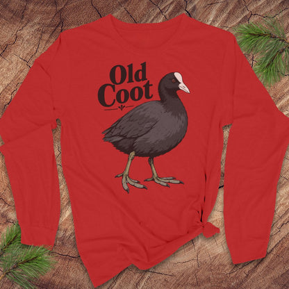 A red long-sleeve t-shirt with a graphic of a dark coot bird and the text 'Old Coot' printed on the chest, displayed flat on a rustic wood background with pine needles.