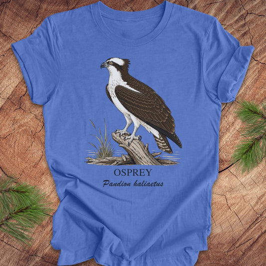 Blue t-shirt with osprey illustration and text on a wooden surface