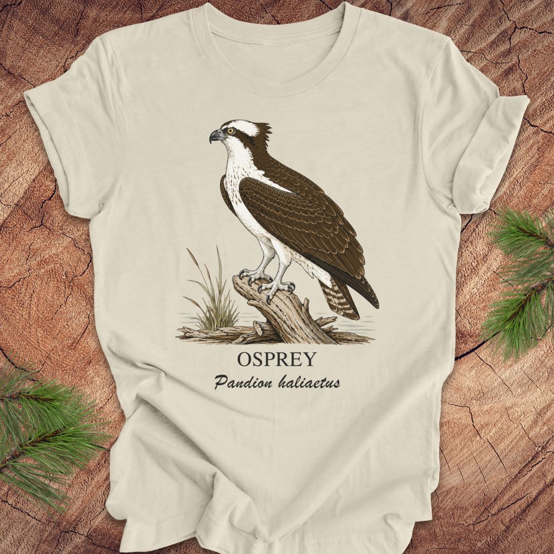 Beige t-shirt with osprey illustration and text on a wooden surface