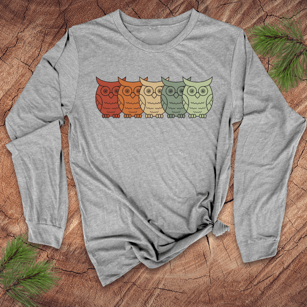 Gray long-sleeve shirt with colorful owl design on a wooden surface