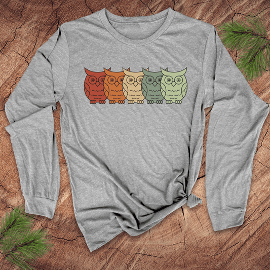 Gray long-sleeve shirt with colorful owl design on a wooden surface