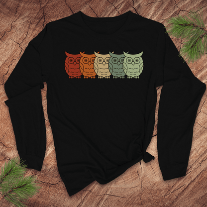Black long sleeve tshirt with colorful owl design on a wooden surface